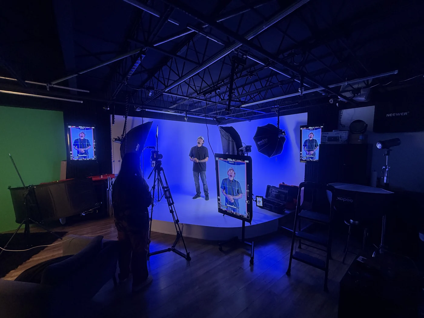 La sala bajo luz azul, un presentador trabajando el green screen