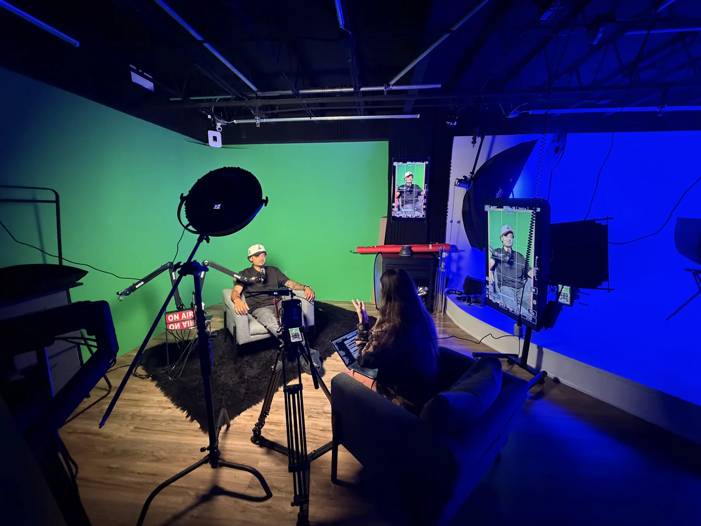 Dos personas grabando en el set con luz azul y verde